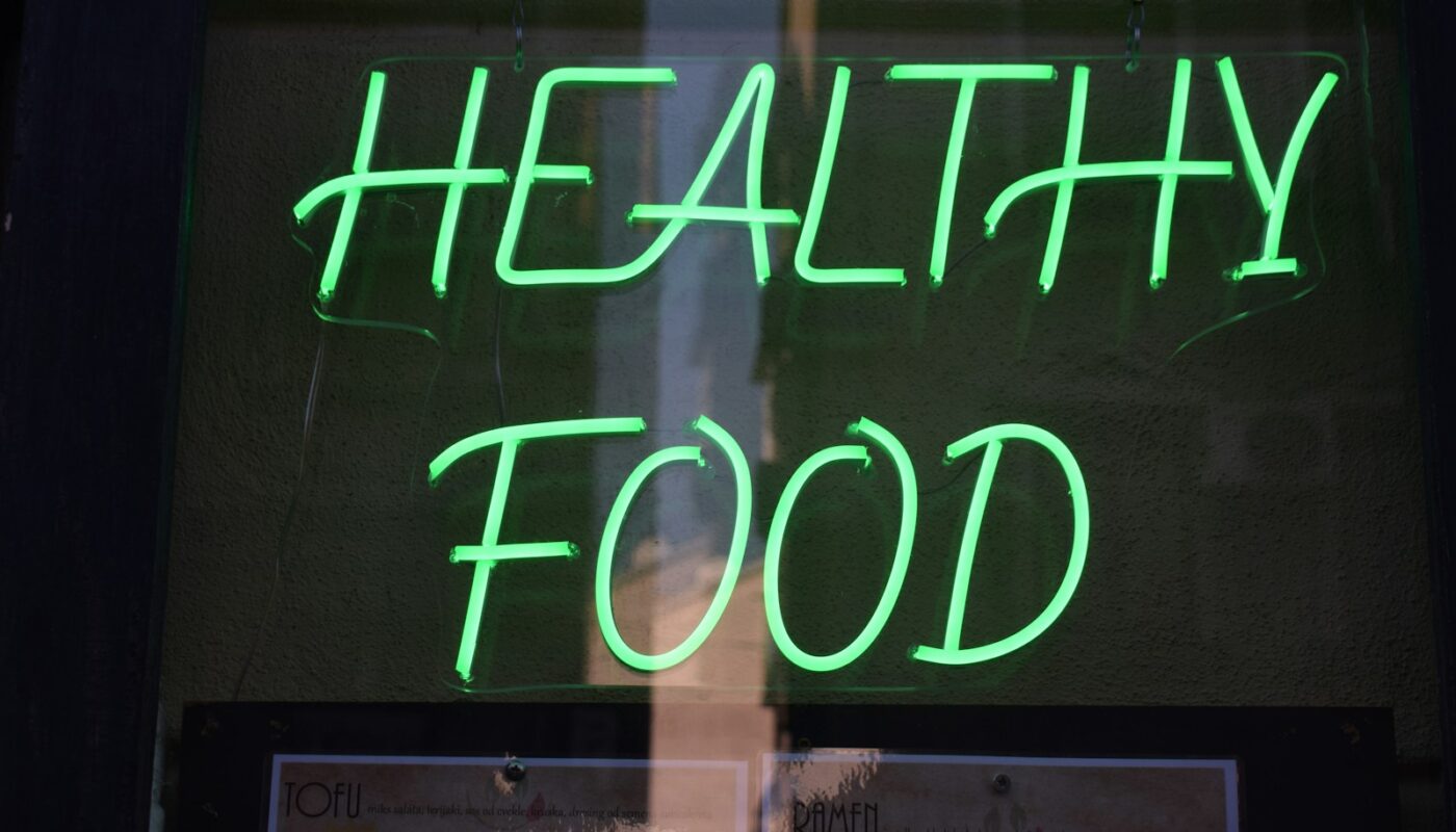 a green neon sign that says healthy food