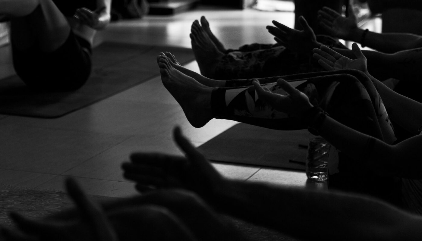 People exercising on yoga mats in a studio.