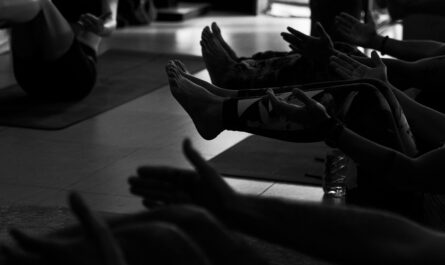 People exercising on yoga mats in a studio.