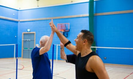 Two men giving each other a high five indoors.