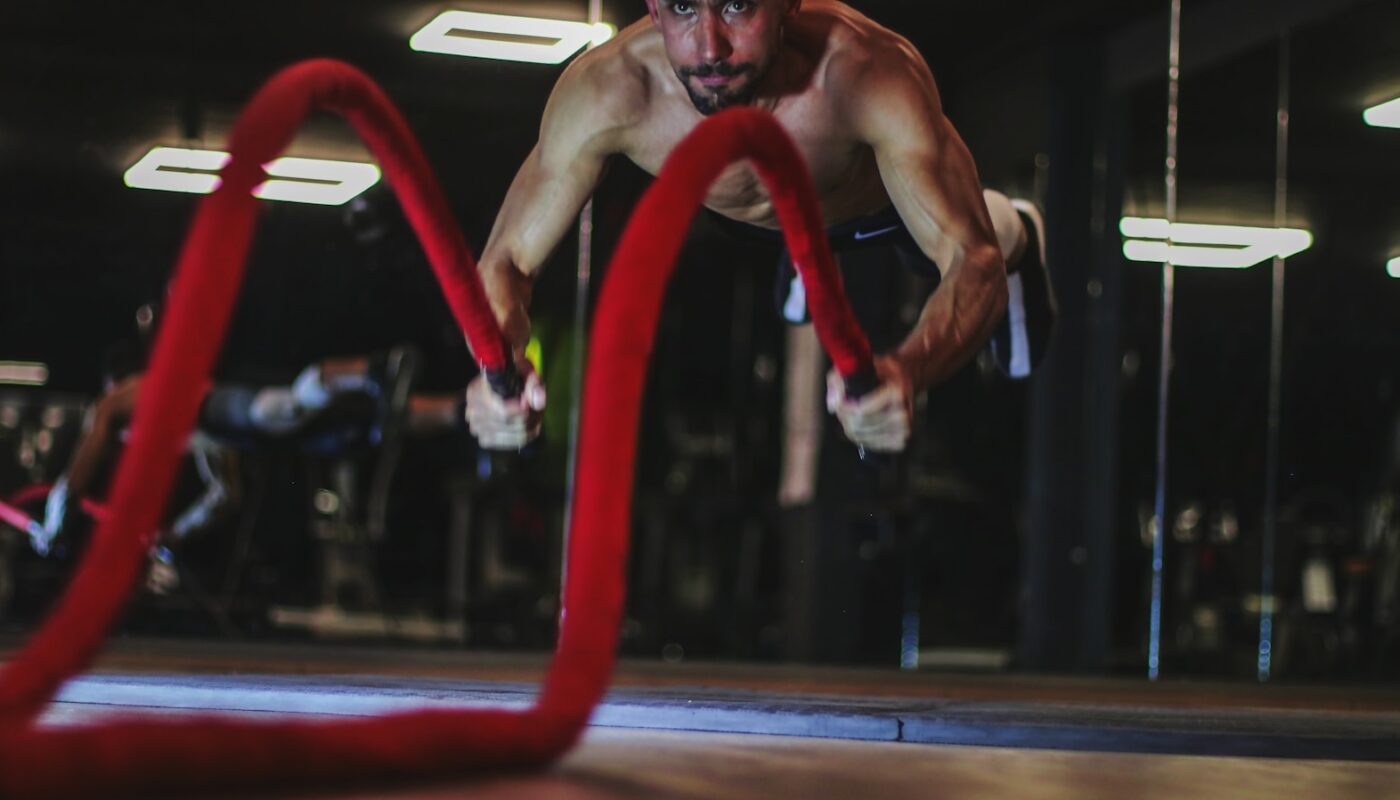 a man doing a push up on a red rope