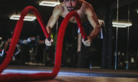 a man doing a push up on a red rope